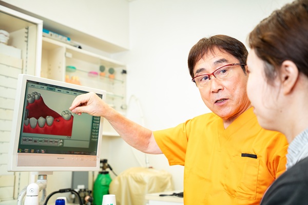 歯科医師が患者さまに治療内容を説明している様子